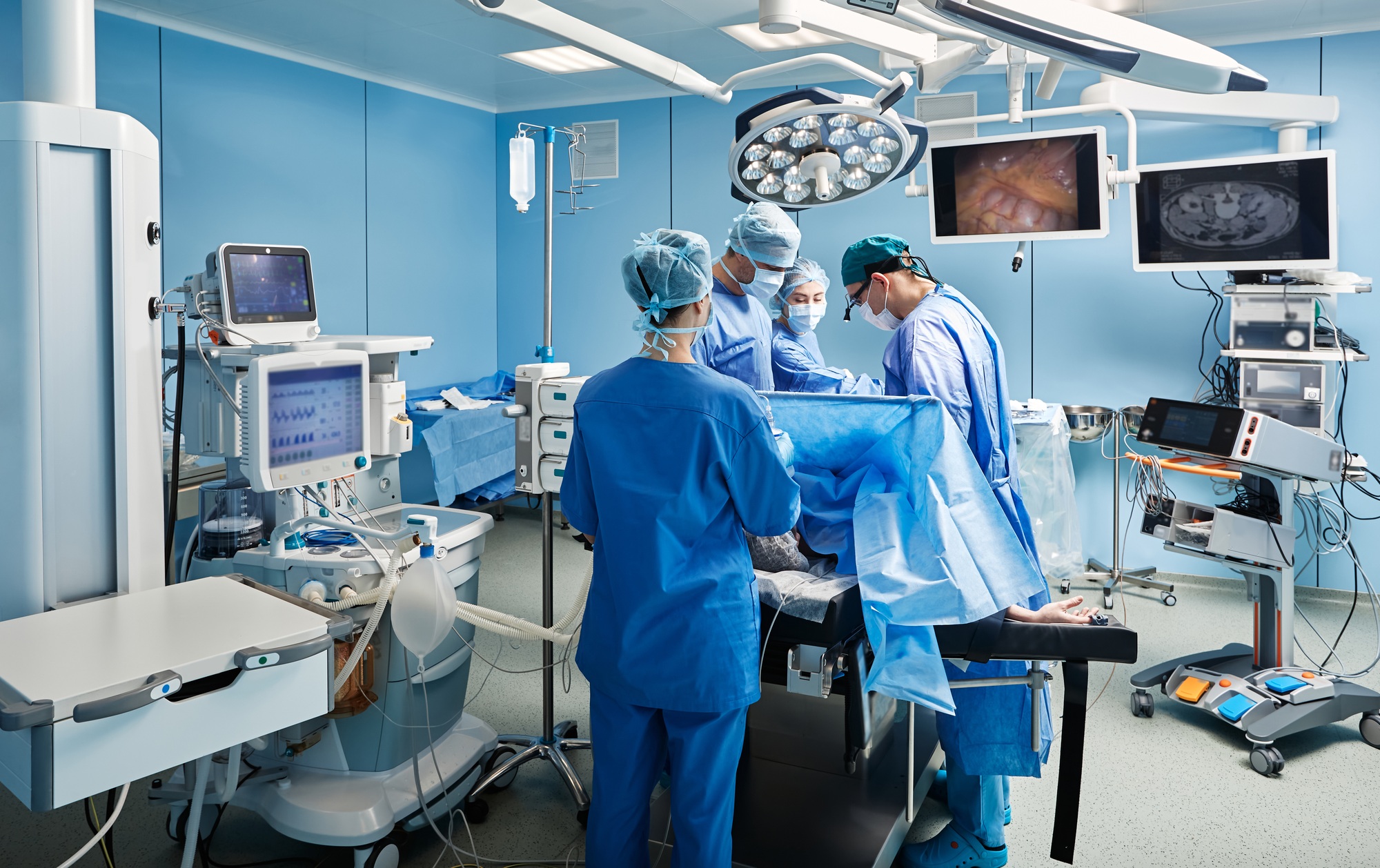 Group of concentrated surgeons while surgical operation in operating theater with nurses and