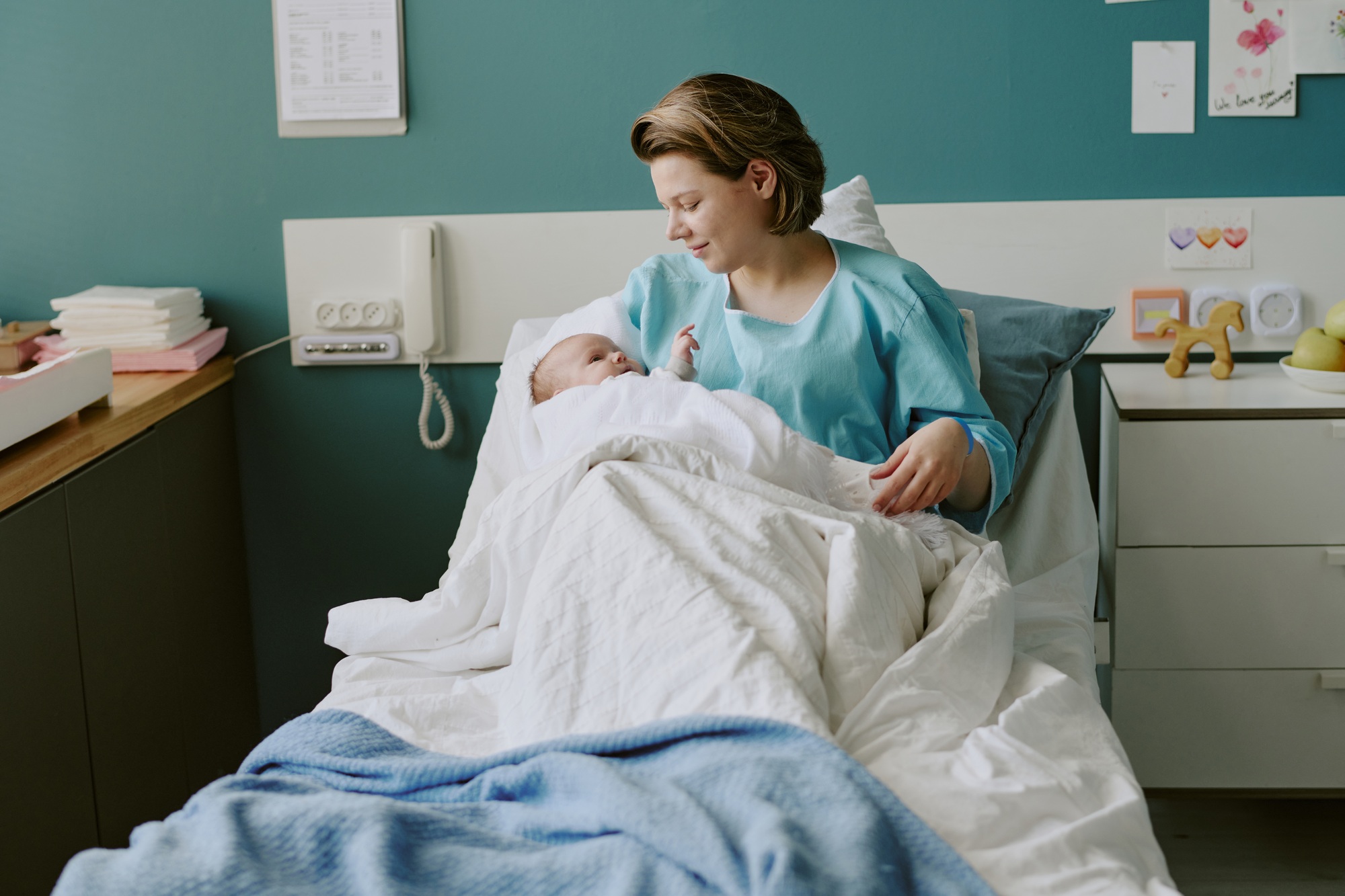 Mother Holding Newborn Baby in Hospital Room