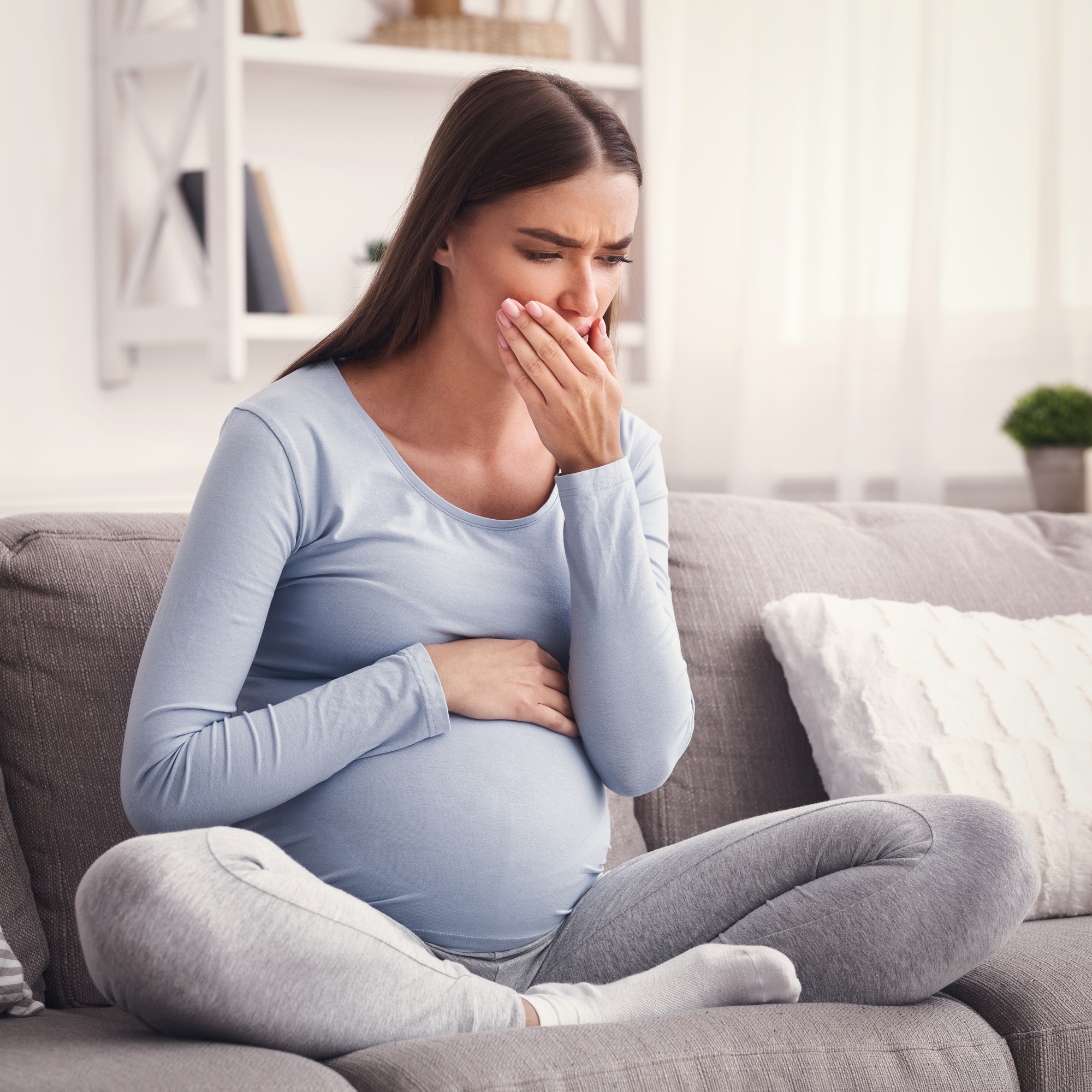 Pregnant Lady Coughing Feeling Sick Touching Mouth Sitting On Sofa