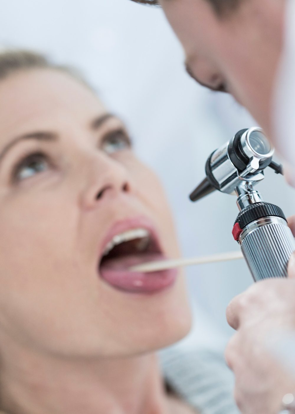 Doctor examining patient's throat